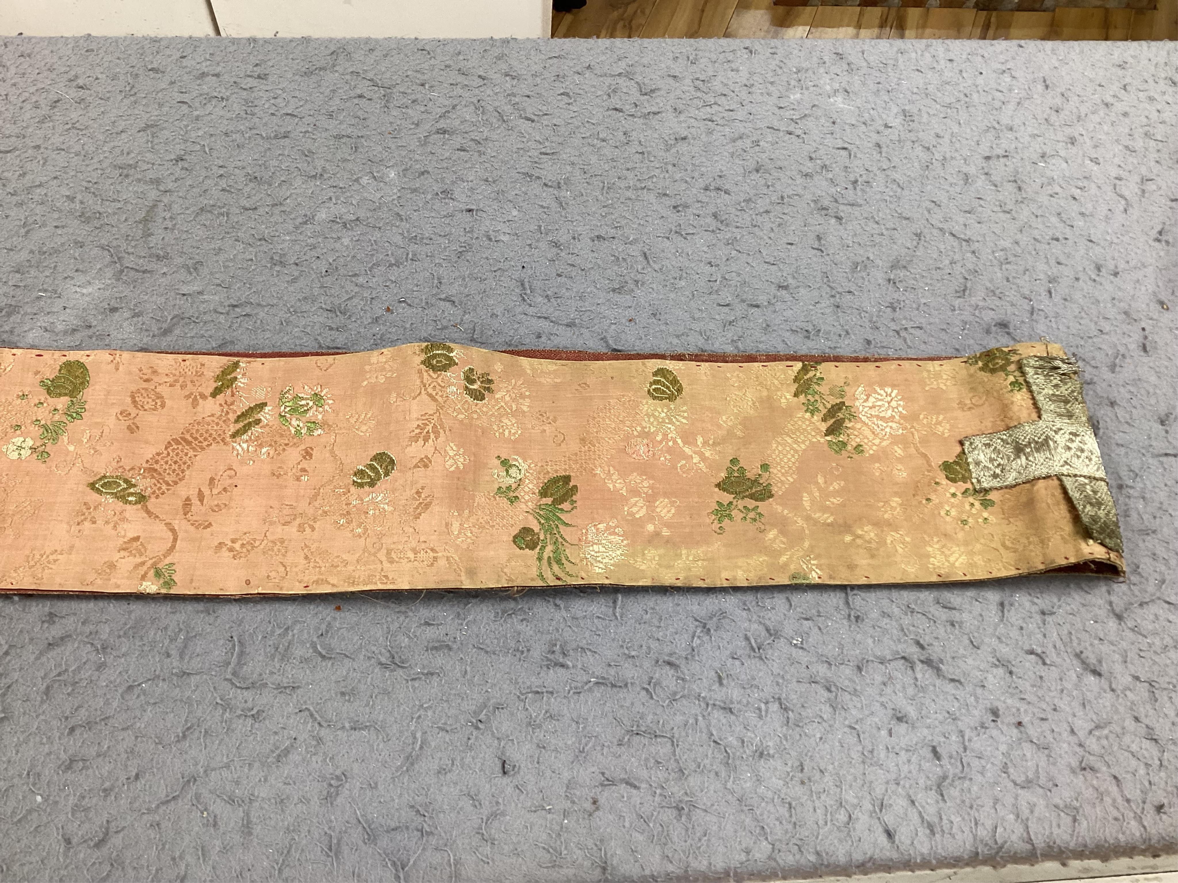A collection of 18th and 19th century textiles, to include religious Maniples, two cushions, an embroidered chain stitch table cover with intricate edging, a Chinese embroidered panel and floral painted satin. Condition